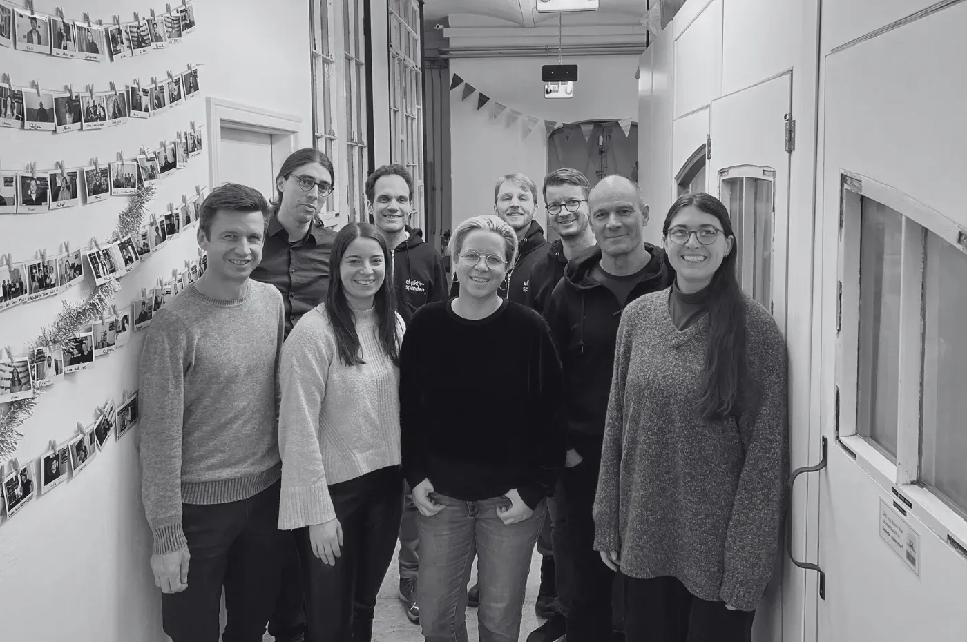 The Effektiv Spenden team in a hallway decorated with photos