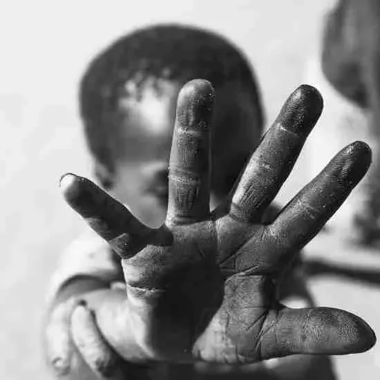 Black-and-white photo: a child reaches out a hand toward the camera