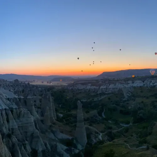 Heißluftballons steigen bei Sonnenuntergang über Kappadokien auf