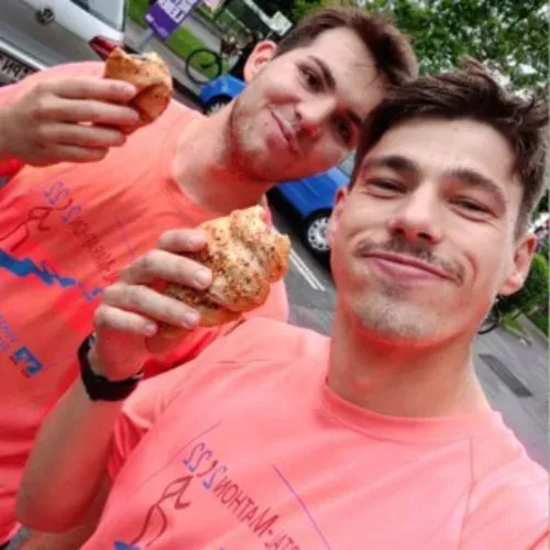 Manuel Hillenmeyer isst mit einem Freund ein Gebäckstück nach dem Lauf