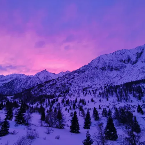 Schneebedeckte Berge im violetten Abendlicht