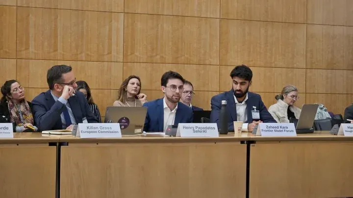 Henry Papadatos von SaferAI auf einem Podium neben Kilian Gross von der Europäischen Kommission