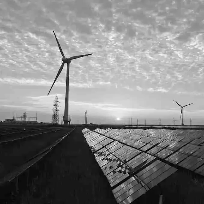 Windrad und Solarpanels bei Sonnenuntergang