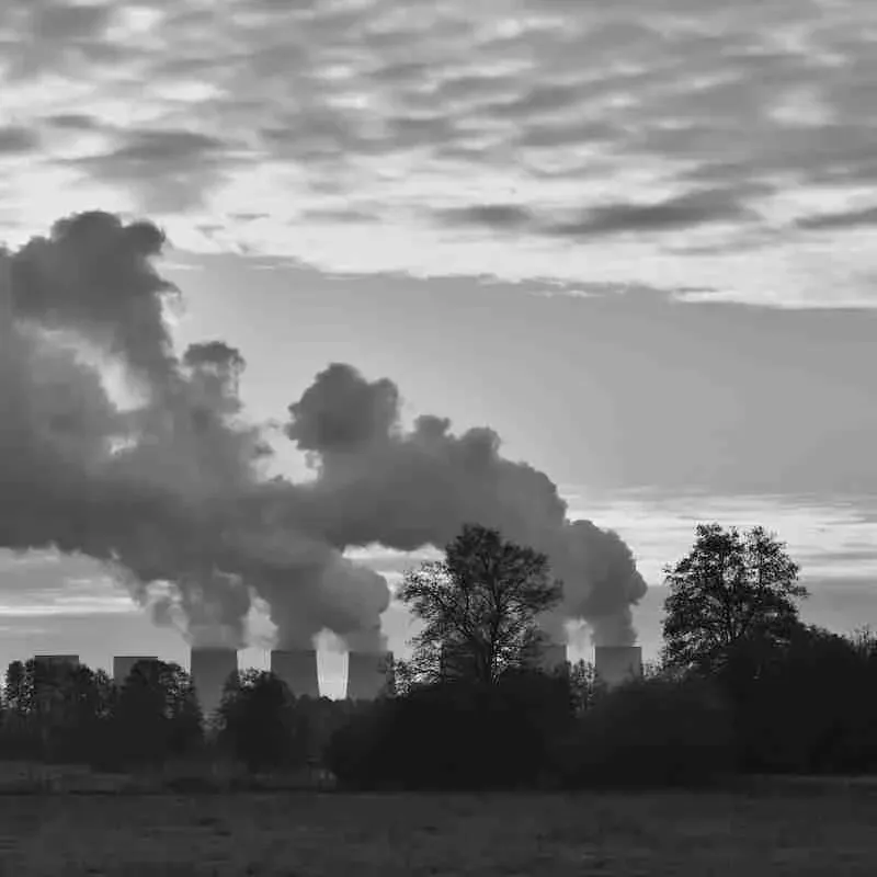 Cooling towers of a power plant releasing smoke into the evening sky